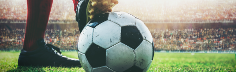 Joven profesional futbolista con pelota en el pie